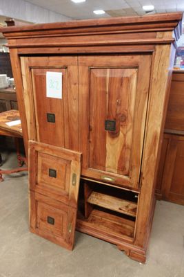 une armoire en bois dont la porte est ouverte, dans une pièce