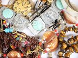 a pile of assorted jewelry on a white surface