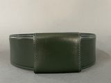 green leather wristband with stitching on a plain surface