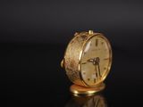 an image of a gold clock sitting on top of a black table