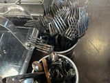 de nombreuses cuillères et fourchettes dans un saladier posé sur une table