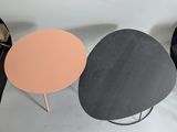 three different colored tables sitting next to each other on a white surface