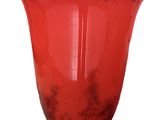 a red vase that is sitting on a white surface