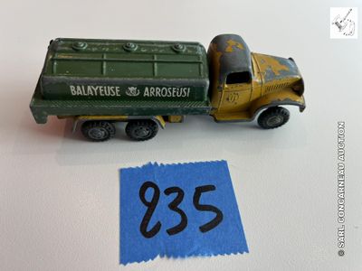 un petit camion vert avec une étiquette bleue dessus