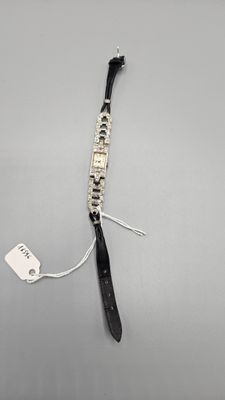 a close up of a black and white bracelet with a tag on it