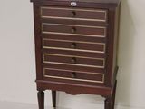 a small chest of drawers on a stand in a room