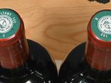 several bottles of wine are in a wooden holder on a counter