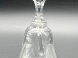 a clear glass bell on a table with a black background