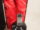 a bottle of liquor in a black box on a white surface