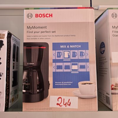 des paquets de café et une cafetière sur une étagère dans un magasin