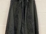 a black jacket hanging on a wall with a white brick wall in the background