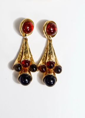 two pairs of earrings with red and black stones on them
