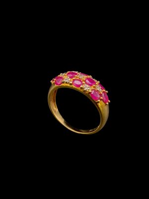 une bague en or sertie de pierres roses sur fond noir