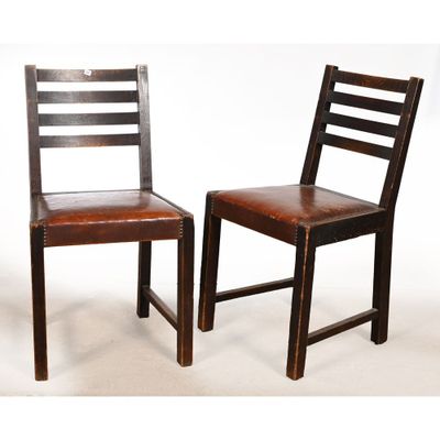 une paire de chaises en bois avec des assises en cuir marron sur fond blanc