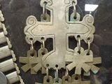 a silver necklace with a cross on it in a display case