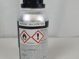 a close up of a bottle of liquid on a white surface