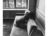 a black and white photo of a woman laying on a couch