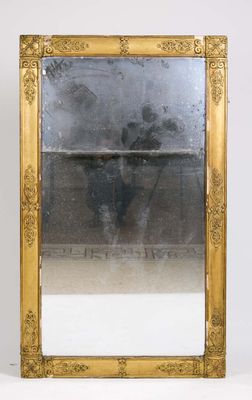 a gold framed mirror sitting on a white surface