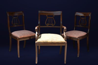 trois chaises en bois avec des coussins rembourrés beiges sur fond noir