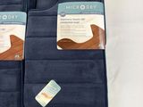 four blue oven mitts are lined up on a white surface
