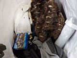 a stuffed owl sitting in a bag of clothes