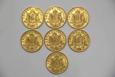 six souverains d'or sont disposés en triangle sur une surface blanche