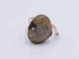a close up of a ring with a stone in it on a white surface