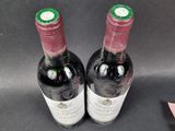 two bottles of wine sitting next to each other on a table