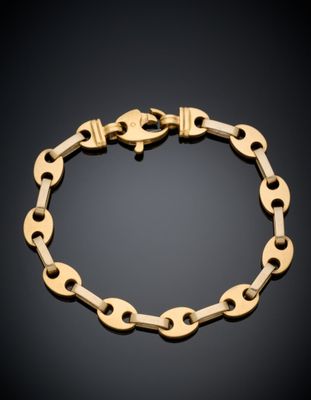 gros plan d'un bracelet en chaîne en or sur fond noir