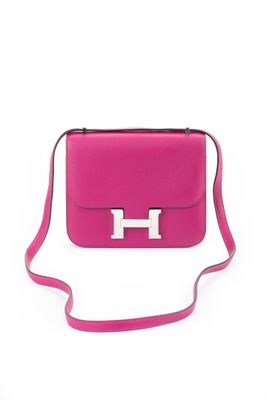a pink purse with a metal handle on a white background