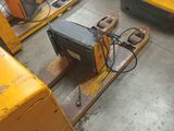 a yellow forklift with a monitor on it in a warehouse
