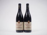 deux bouteilles de vin rouge posées l'une à côté de l'autre sur une surface blanche