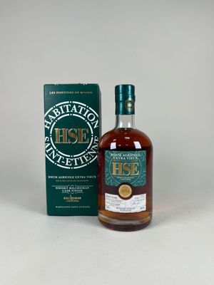 une bouteille de whisky posée sur une table à côté d'un coffret