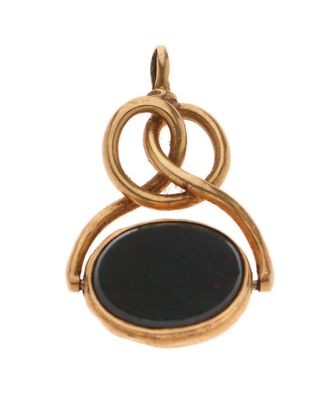 un gros plan d'un pendentif en pierre dorée et noire sur fond blanc