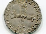 une vieille pièce d'argent sur laquelle figure une croix sur un fond blanc