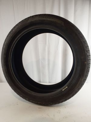 a close up of a tire on a white surface with a curtain in the background