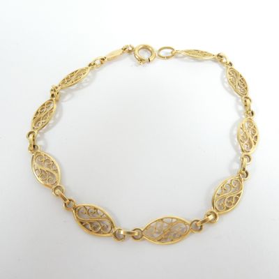a close up of a gold bracelet on a white background