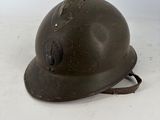 an old helmet with a hole in it sitting on a white surface