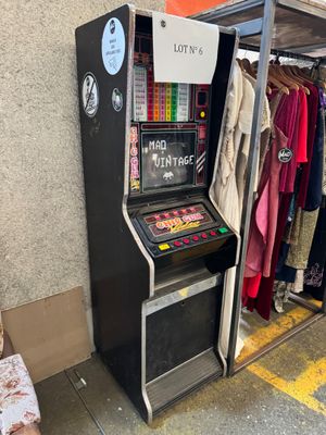 une petite borne d'arcade sur laquelle sont affichés de nombreux vêtements