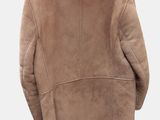 the back of a jacket hanging on a hanger on a white wall