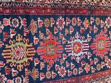rug on the floor is blue and red with a pattern of flowers on it