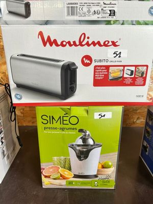 Deux cartons contenant des appareils électroménagers sont posés sur une table dans un magasin.