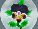 une assiette en verre ornée d'une fleur, posée sur une table