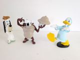 three figurines of cartoon characters on a white surface