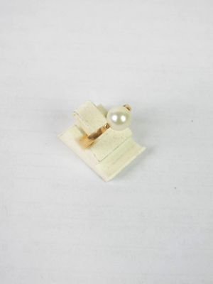 un petit objet blanc orné d'une perle