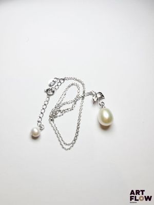 un gros plan d'un collier composé d'une perle montée sur une chaîne