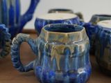 four cups and a teapot sitting on a tray