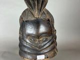 gros plan d'un masque en bois sur un support noir