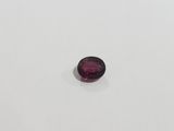 a purple oval shaped gems on a white surface