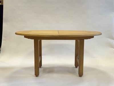 La table est en bois et possède un plateau incurvé.